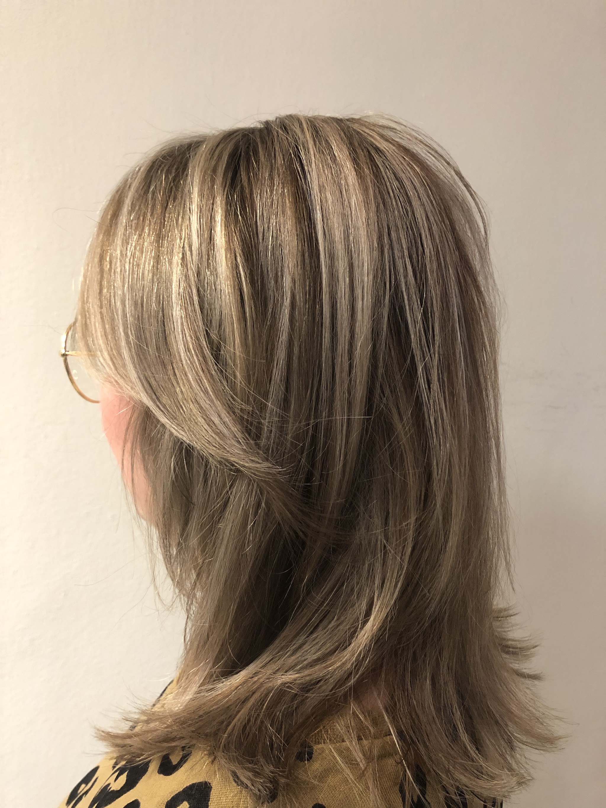 Halflang haar in laagjes met blonde highlights, van opzij gezien